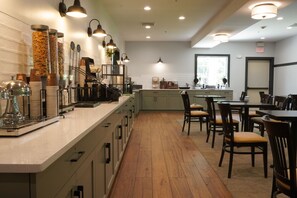 A restaurant interior with a long counter, dining area, and kitchen in the background.