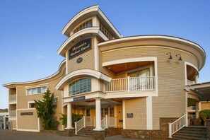 Un hôtel de deux étages, doté d’une façade incurvée, d’un balcon et d’une enseigne indiquant l’entrée.