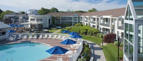 Un hotel con piscina, lettini e ombrelloni.