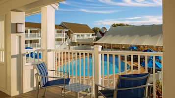 Relax by the pool surrounded by a deck with lounge chairs and a shaded canopy.