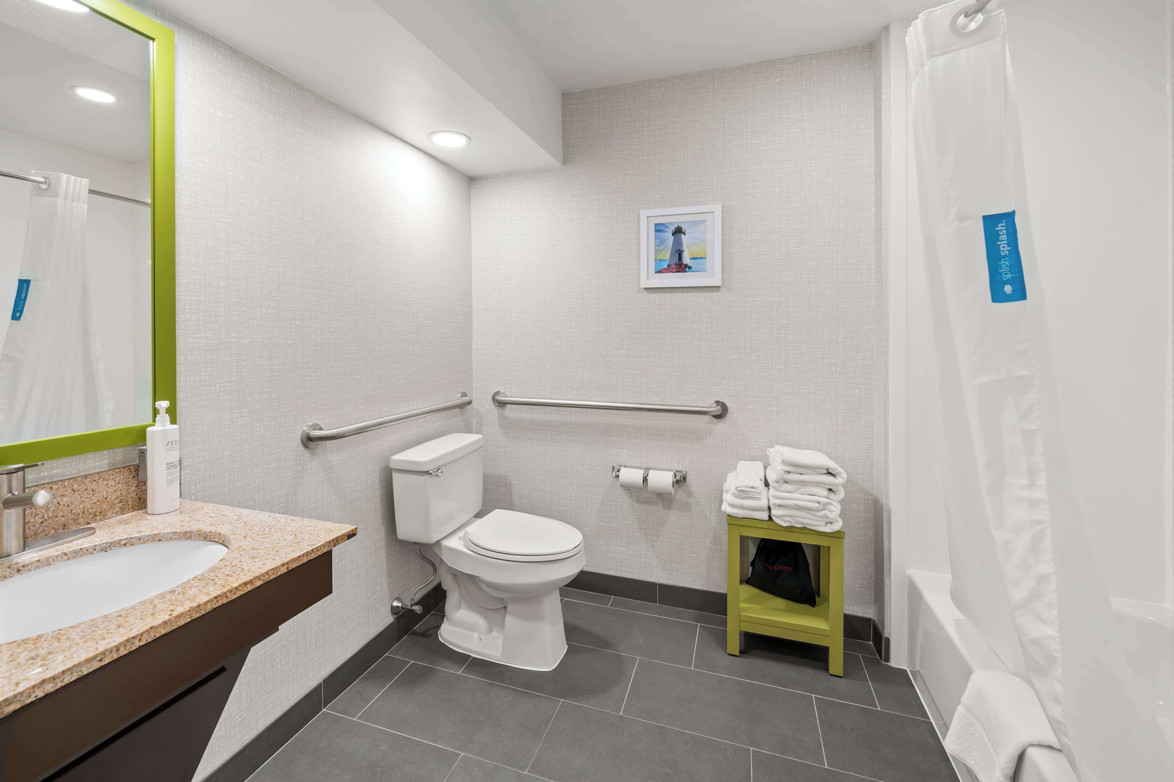 A modern bathroom with a sink, toilet, and shower.