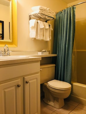A bathroom with a white sink, a toilet, and a shower curtain.