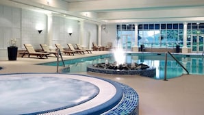 A large indoor swimming pool with lounge chairs and a hot tub area. - The Goodwood Hotel (Chichester)
