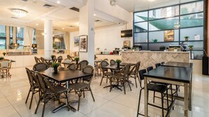 A spacious restaurant with high ceilings, modern furniture, and large windows offering natural light. - Hotel Diana Woolloongabba (Woolloongabba)