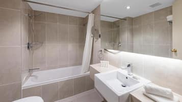 Ein modernes Badezimmer mit Badewanne, Dusche, Toilette und Waschbecken.