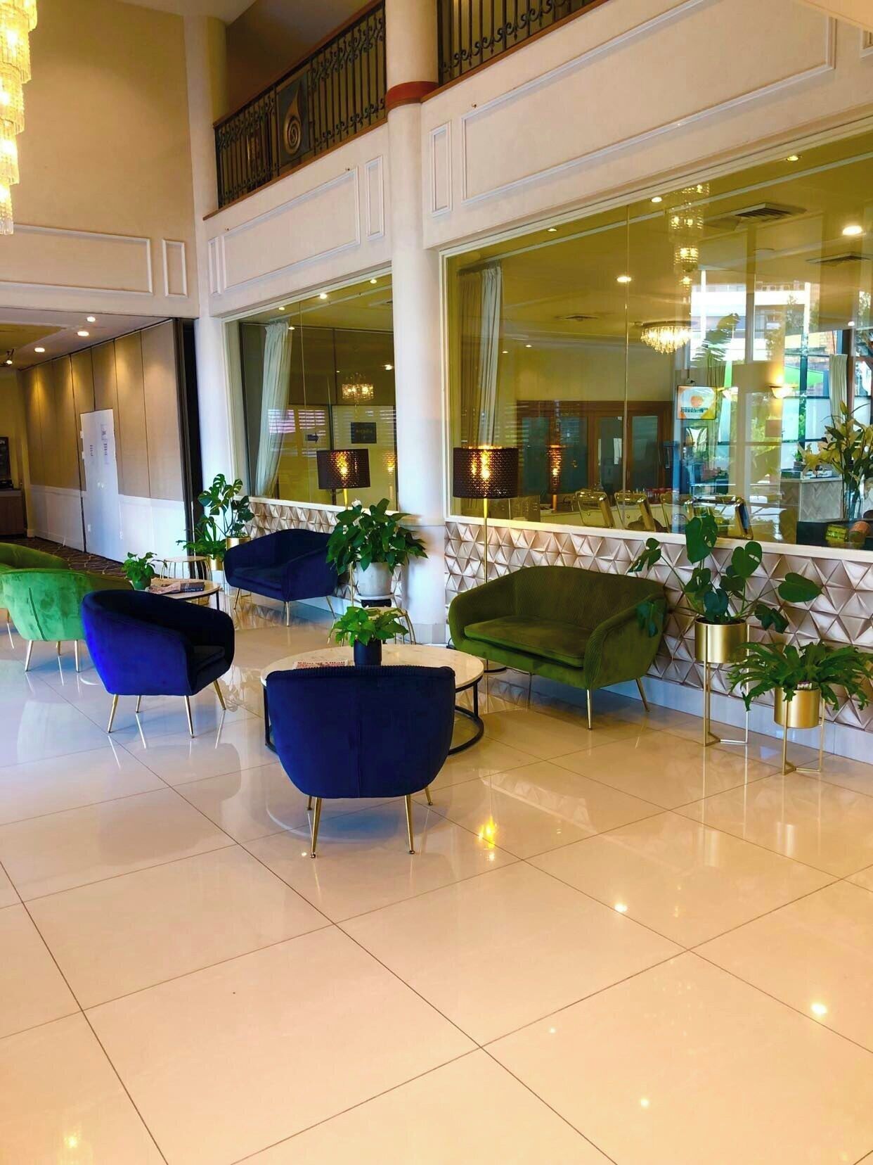 Un hall d’entrée spacieux, doté de meubles modernes, de grandes fenêtres et de plantes décoratives.