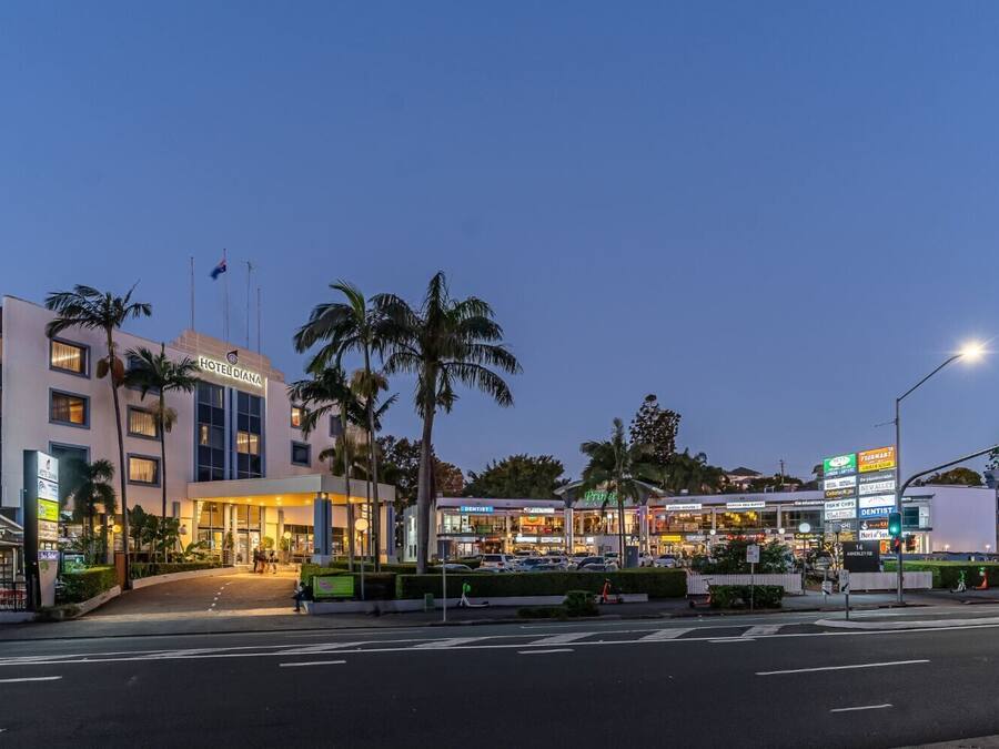 A hotel with a modern design, a prominent sign, and a well-lit entrance.