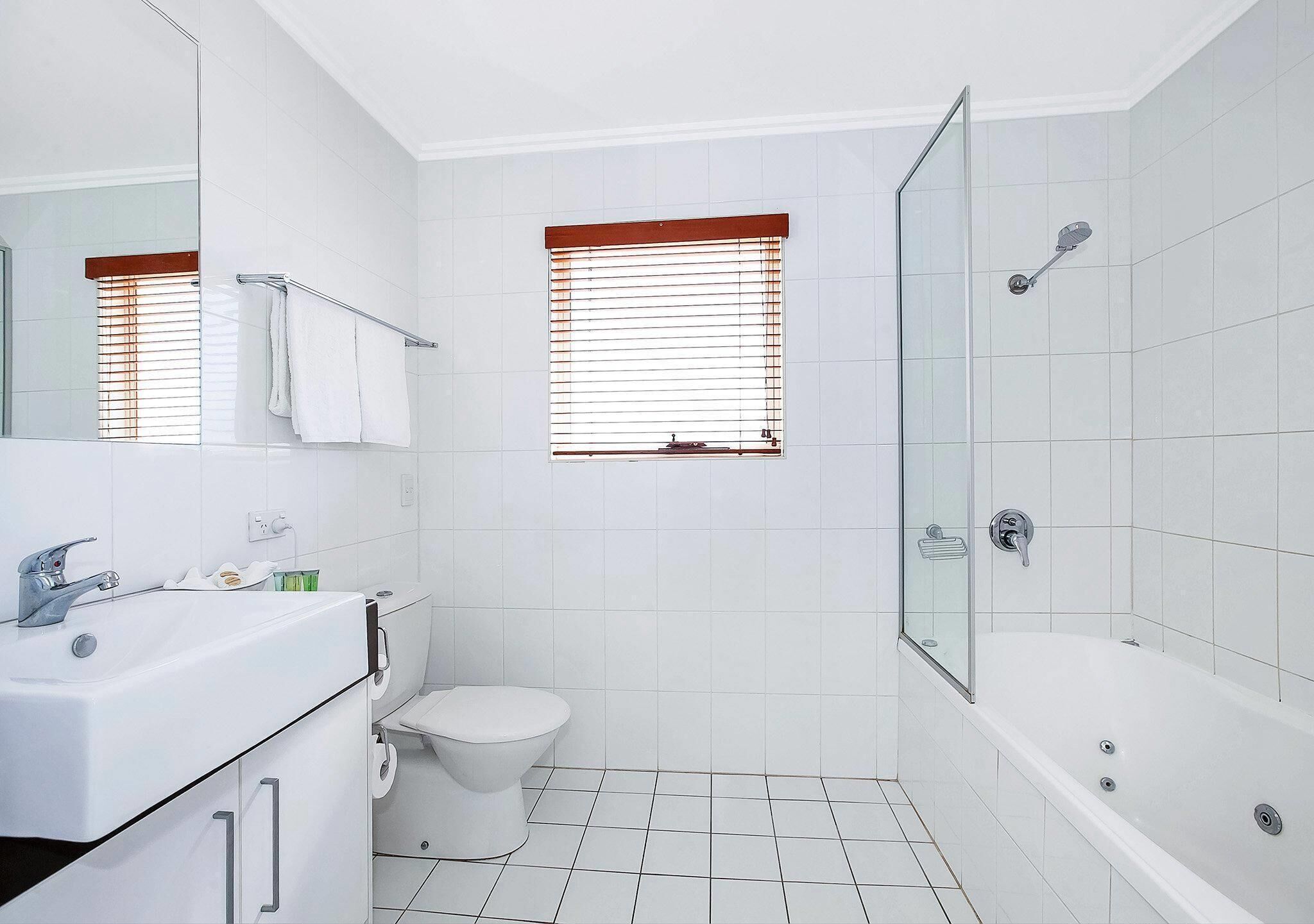 A modern bathroom with a bathtub, toilet, and sink.