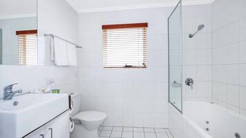 A modern bathroom with a bathtub, toilet, and sink.