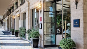 A hotel entrance with a tiled floor, potted plants, and a sign reading "HOTEL BRIGHTON". - Hotel Brighton (Paris)