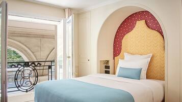 Ein Hotelzimmer mit einem großen Bett, einem dekorativen Kopfteil und Blick auf einen Balkon.