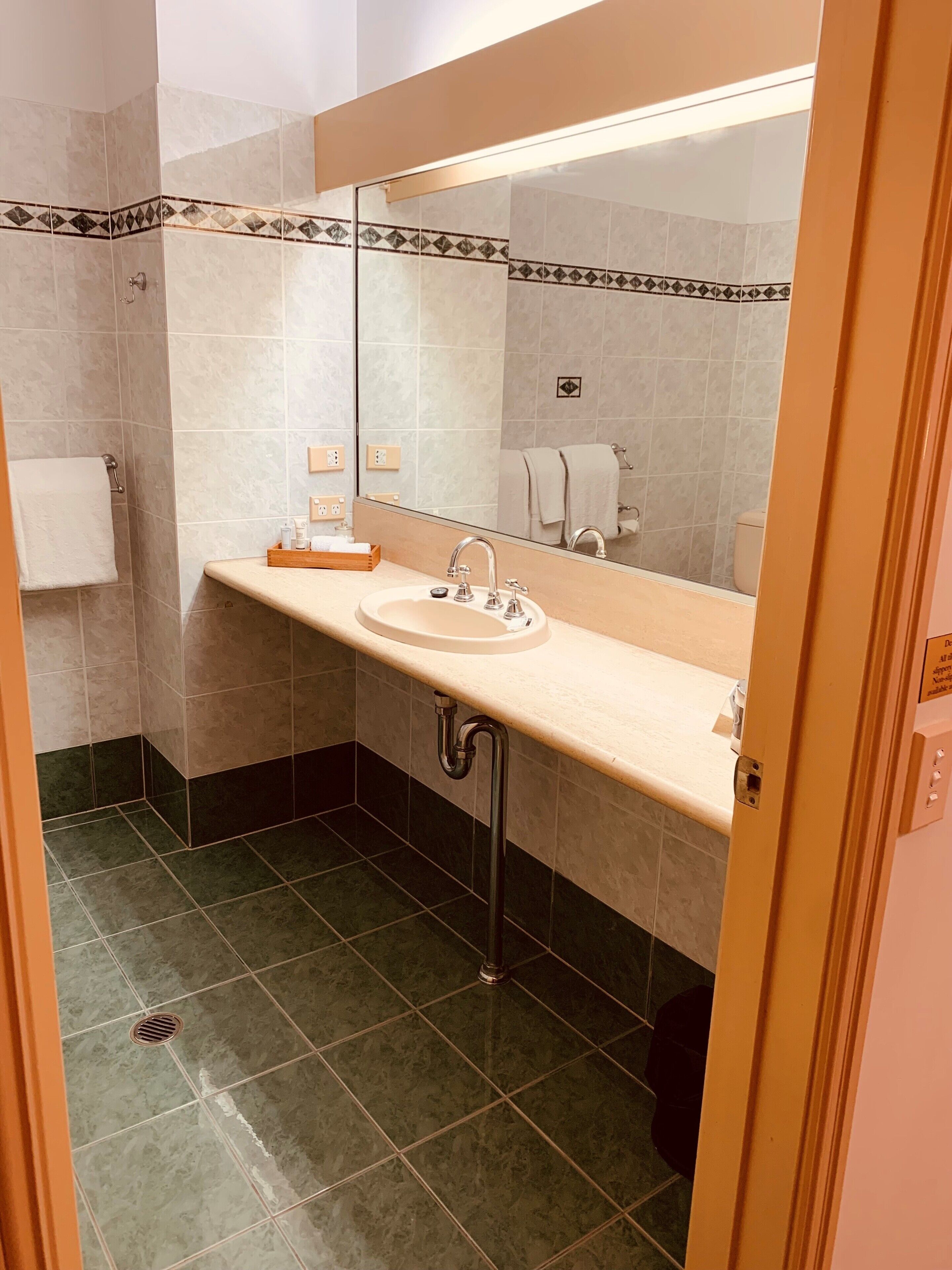 A bathroom with a sink, mirror, and towel rack.