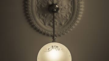 Una lámpara de pared con una placa decorativa y un capuchón esférico.