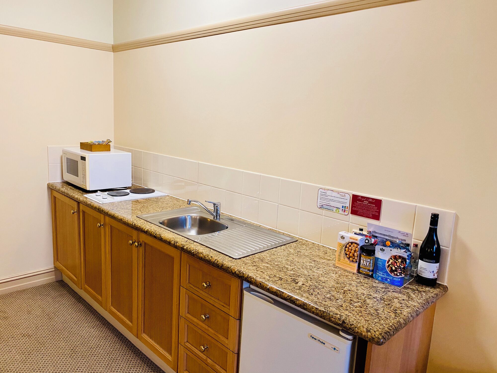 A compact kitchen with a microwave, sink, and refrigerator.