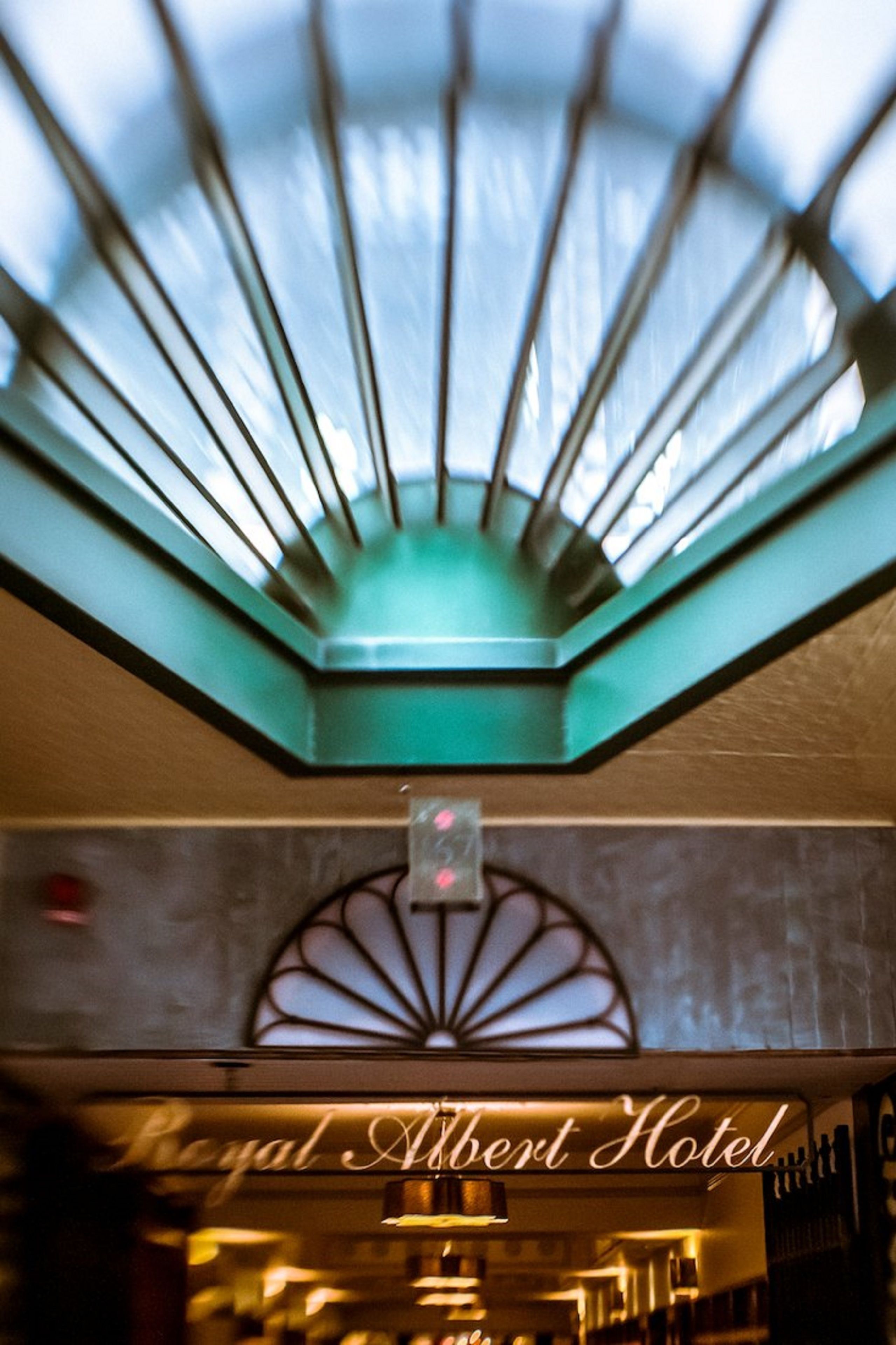 A hotel interior with a skylight and a sign reading "Royal Albert Hotel".