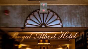 A hotel interior with a skylight and a sign reading "Royal Albert Hotel".