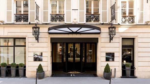 A hotel entrance with a black awning, double doors, and a 'R' logo on the ground. - Renaissance Paris Vendome Hotel (Paris)
