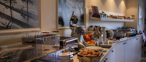A buffet area with various food stations, including a fruit bowl and a coffee station.