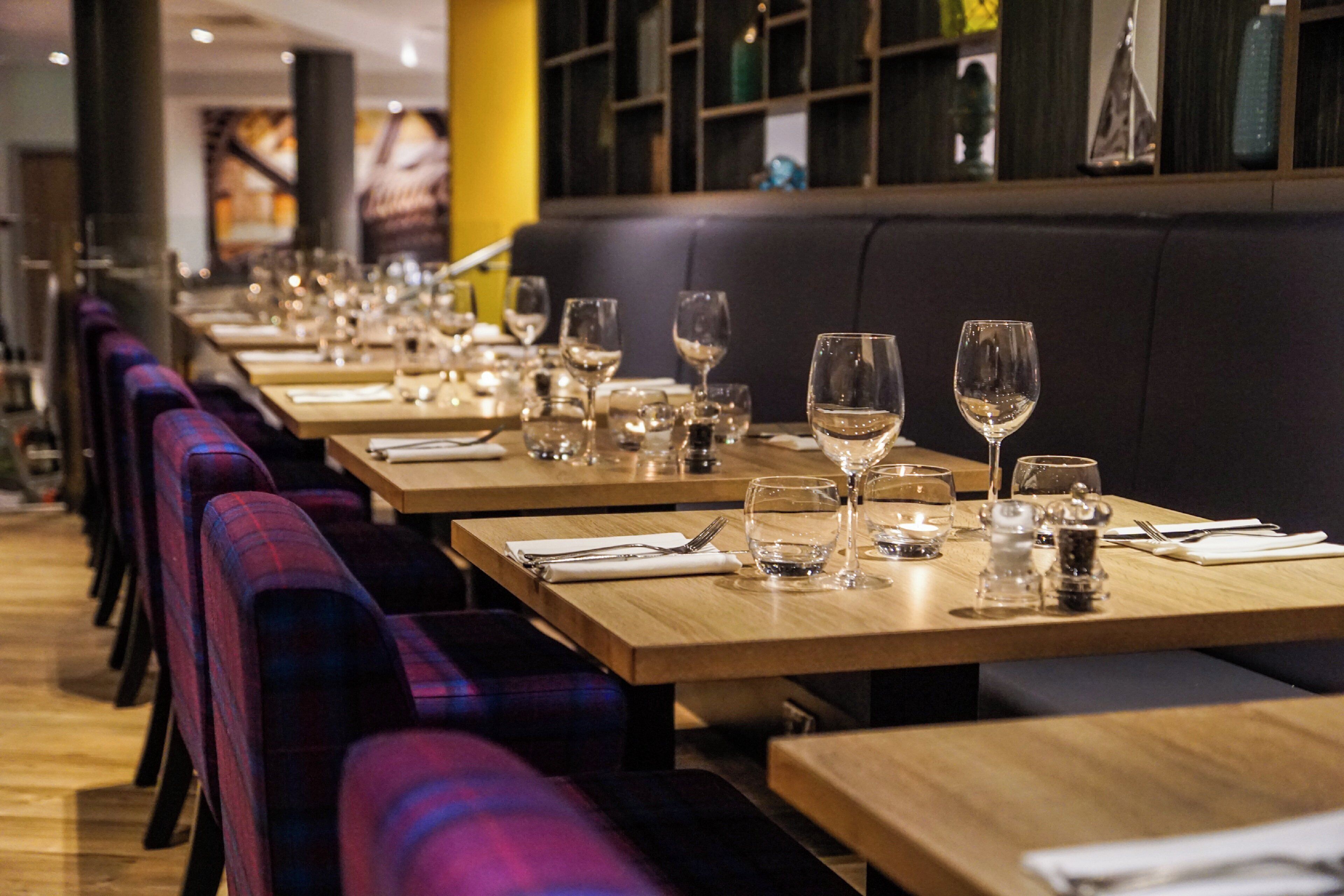 Un restaurant avec de longues tables, des bancs et une rangée de chaises.