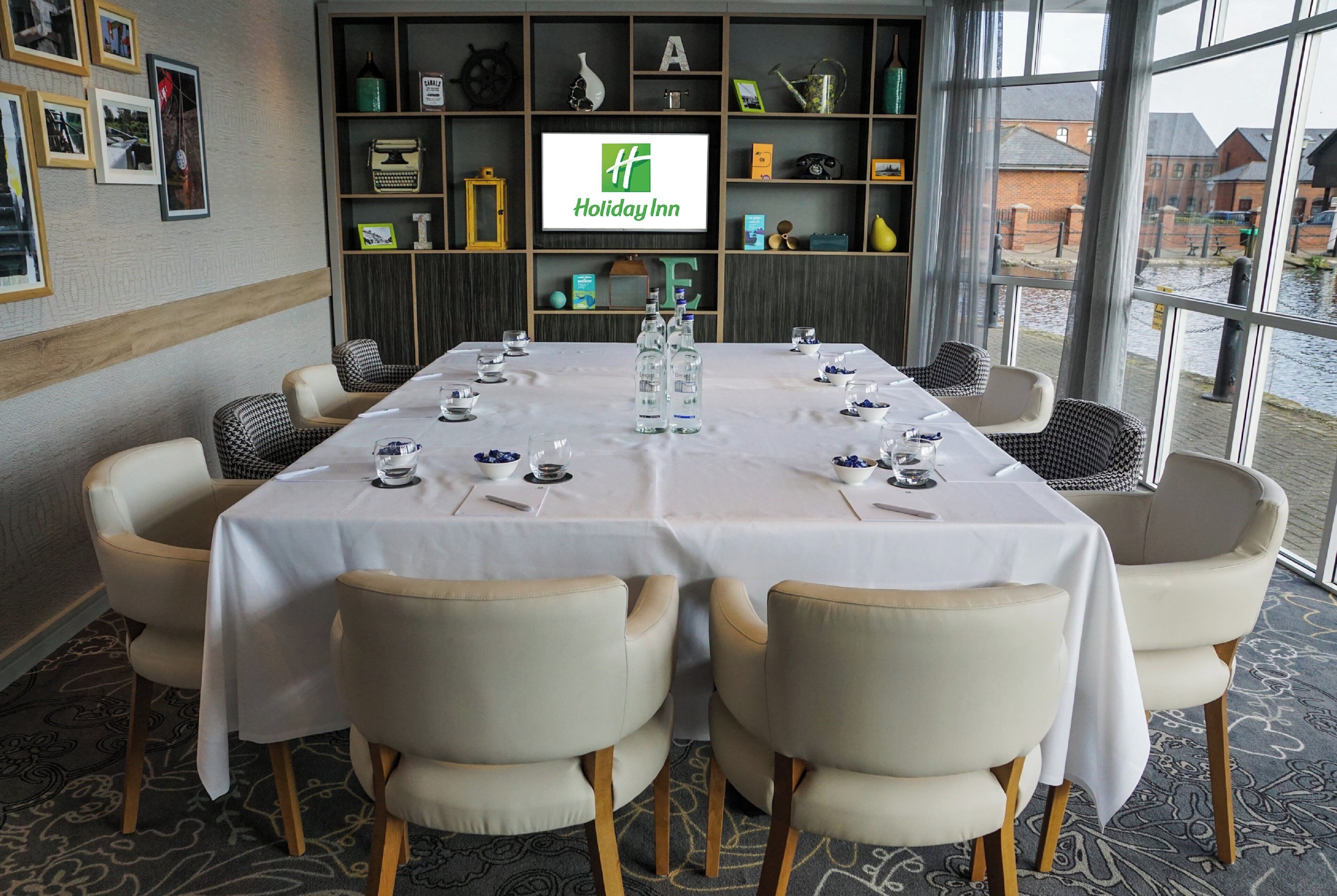 A conference room with a white table, chairs, and a large window.