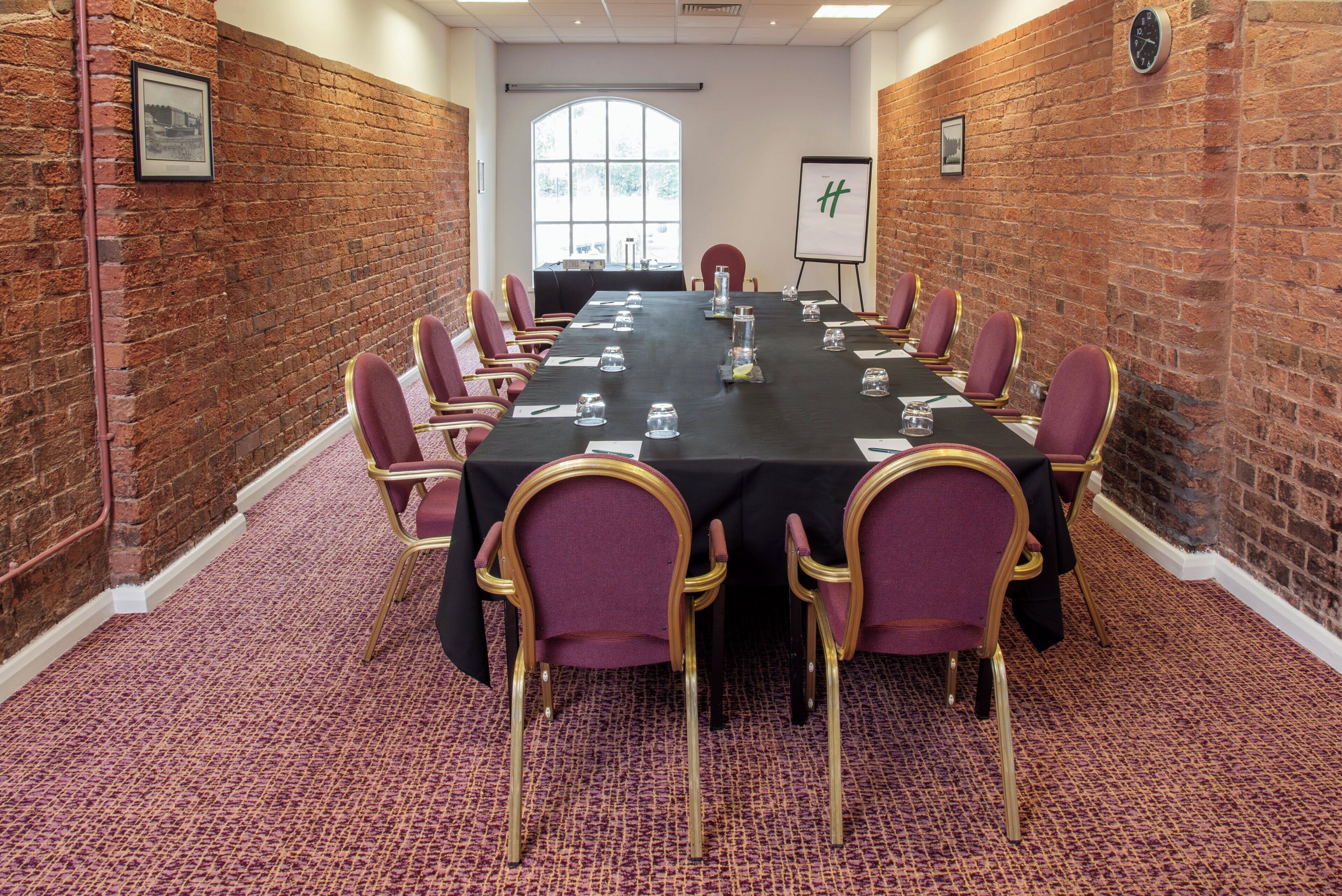 A conference room with a long table, chairs, and a whiteboard.