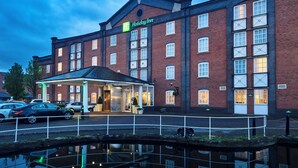 A Holiday Inn hotel with a brick facade, multiple windows, and a covered entrance.