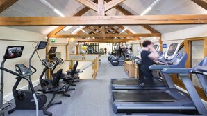 Une salle de sport équipée de tapis de course, de vélos elliptiques et de matériel de musculation.