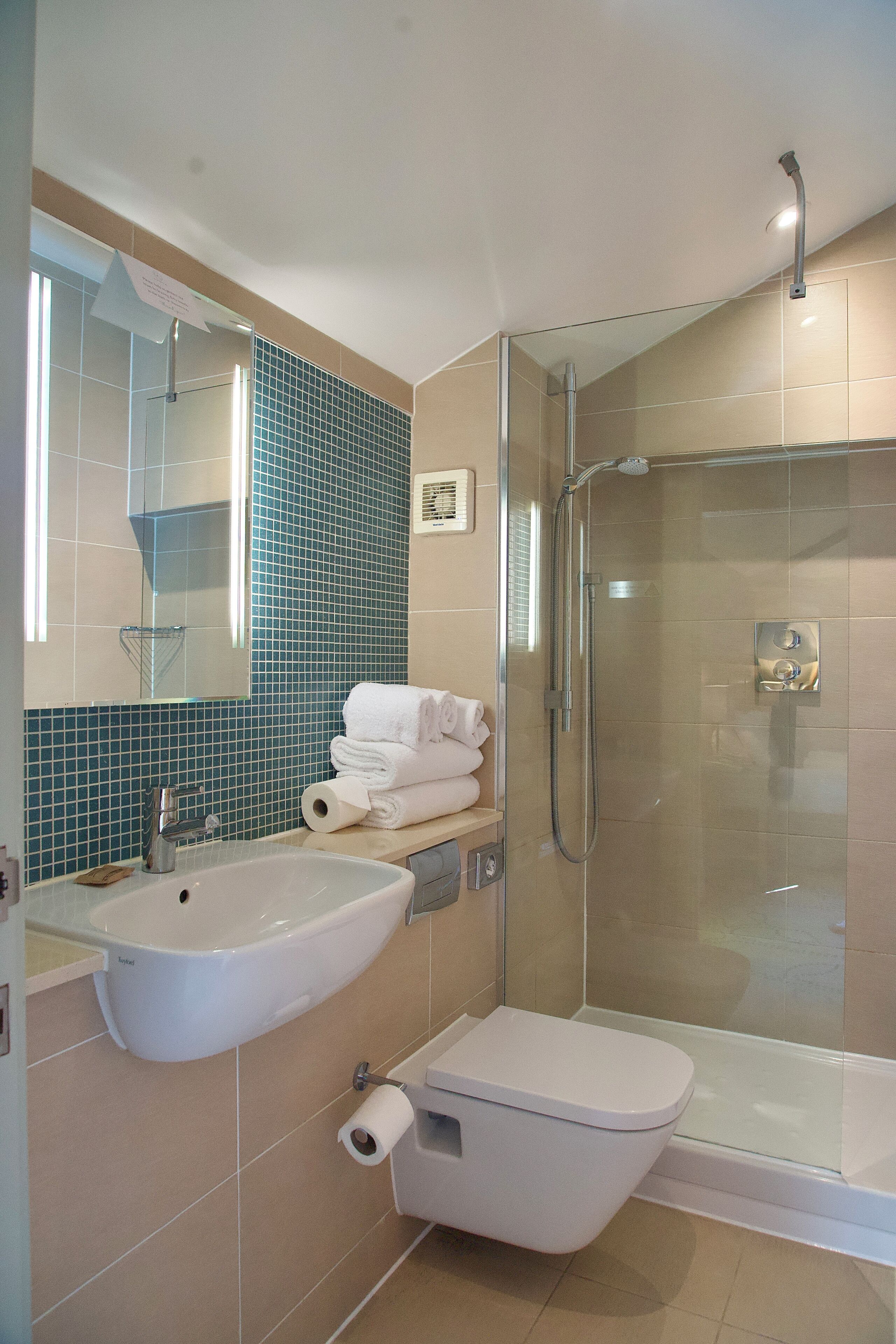 A bathroom with a sink, toilet, and glass-enclosed shower.