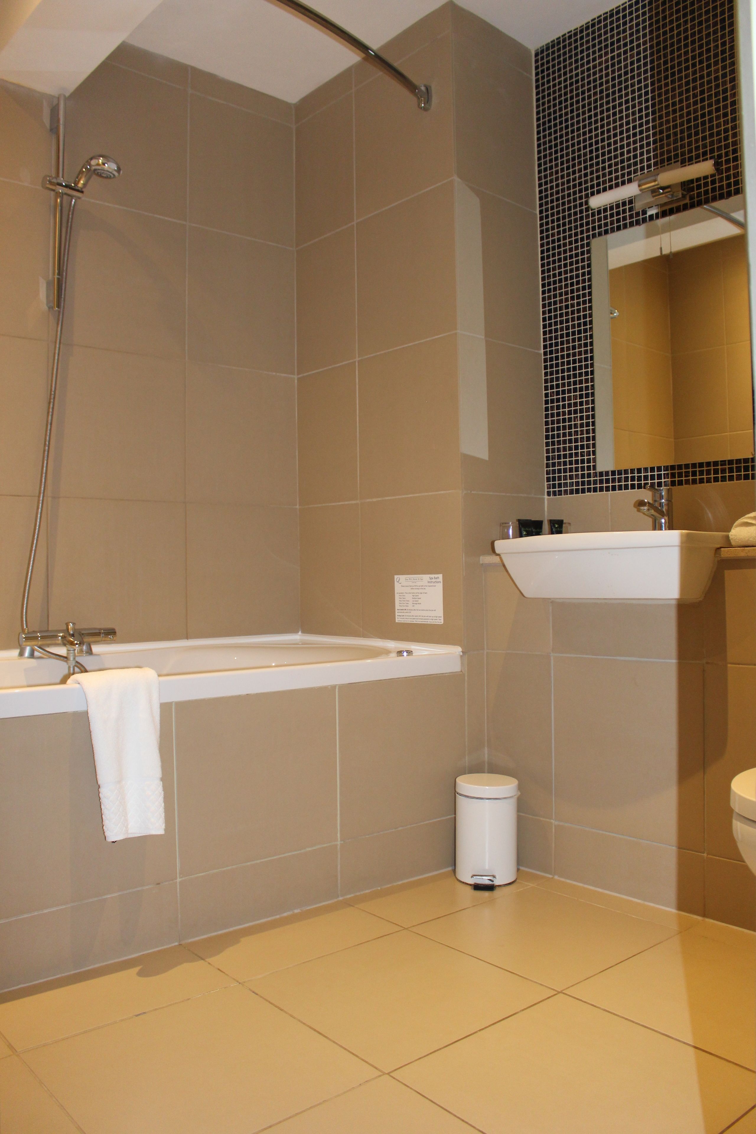 Un baño con bañera, lavamanos e inodoro.