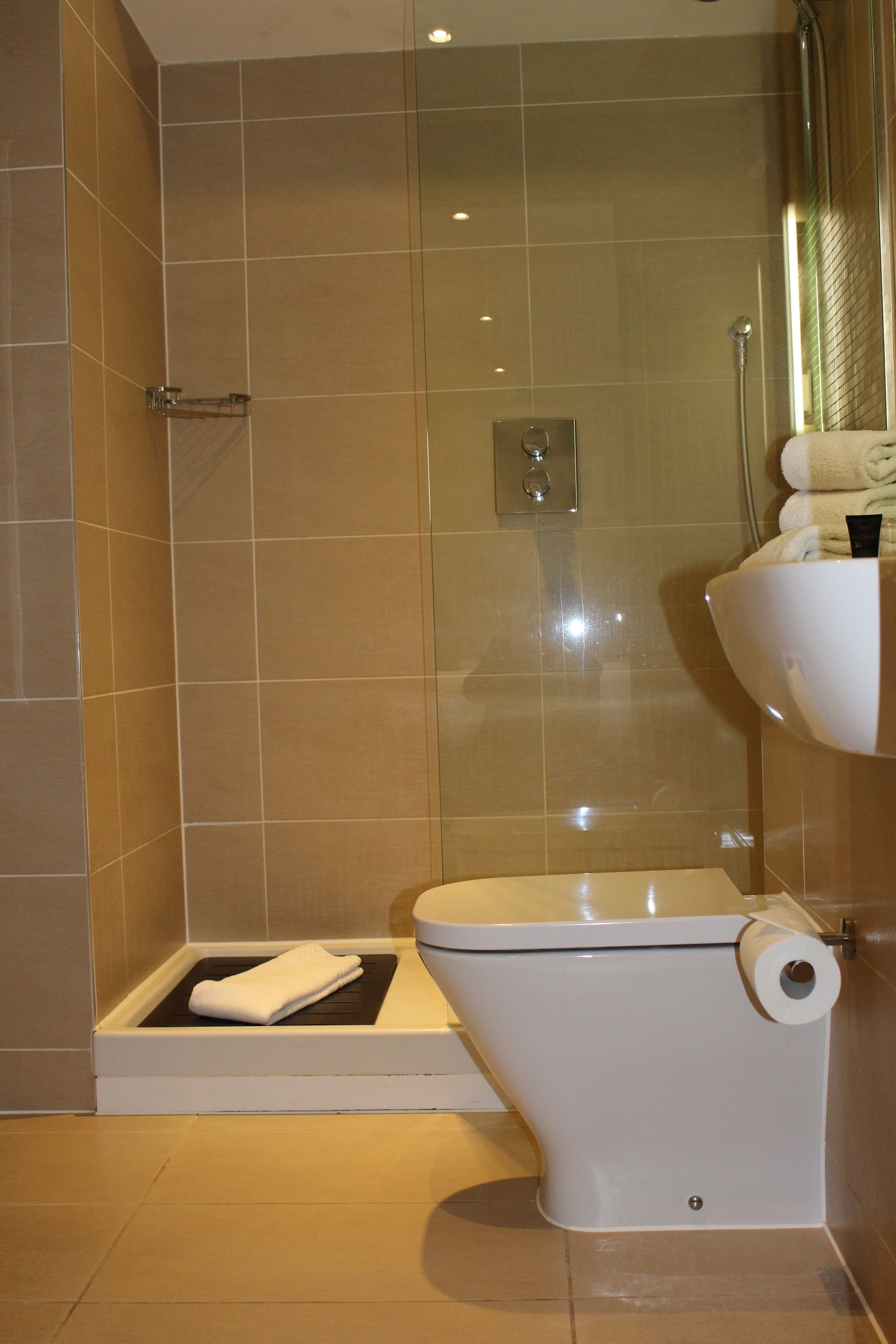 A bathroom with a shower, toilet, and sink.