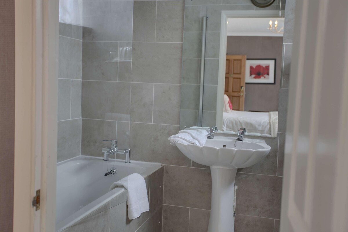 Ein Badezimmer mit Badewanne, Waschbecken und Spiegel.