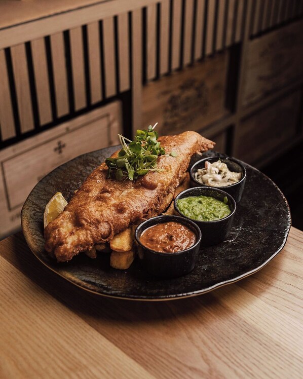 A plate of fish and chips with various sauces and a lemon wedge. - Weston Hall Hotel, Sure Hotel Collection by Best Western (Bedworth)