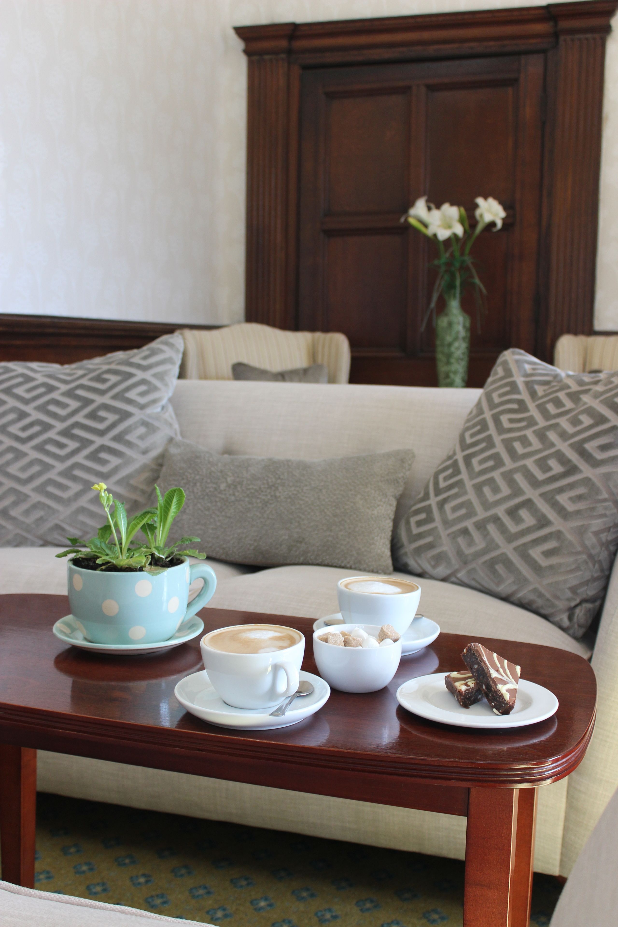 Un salon chaleureux avec une table basse, un canapé et des coussins à motifs.