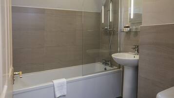 A modern bathroom with a glass-enclosed shower, a white bathtub, and a pedestal sink.
