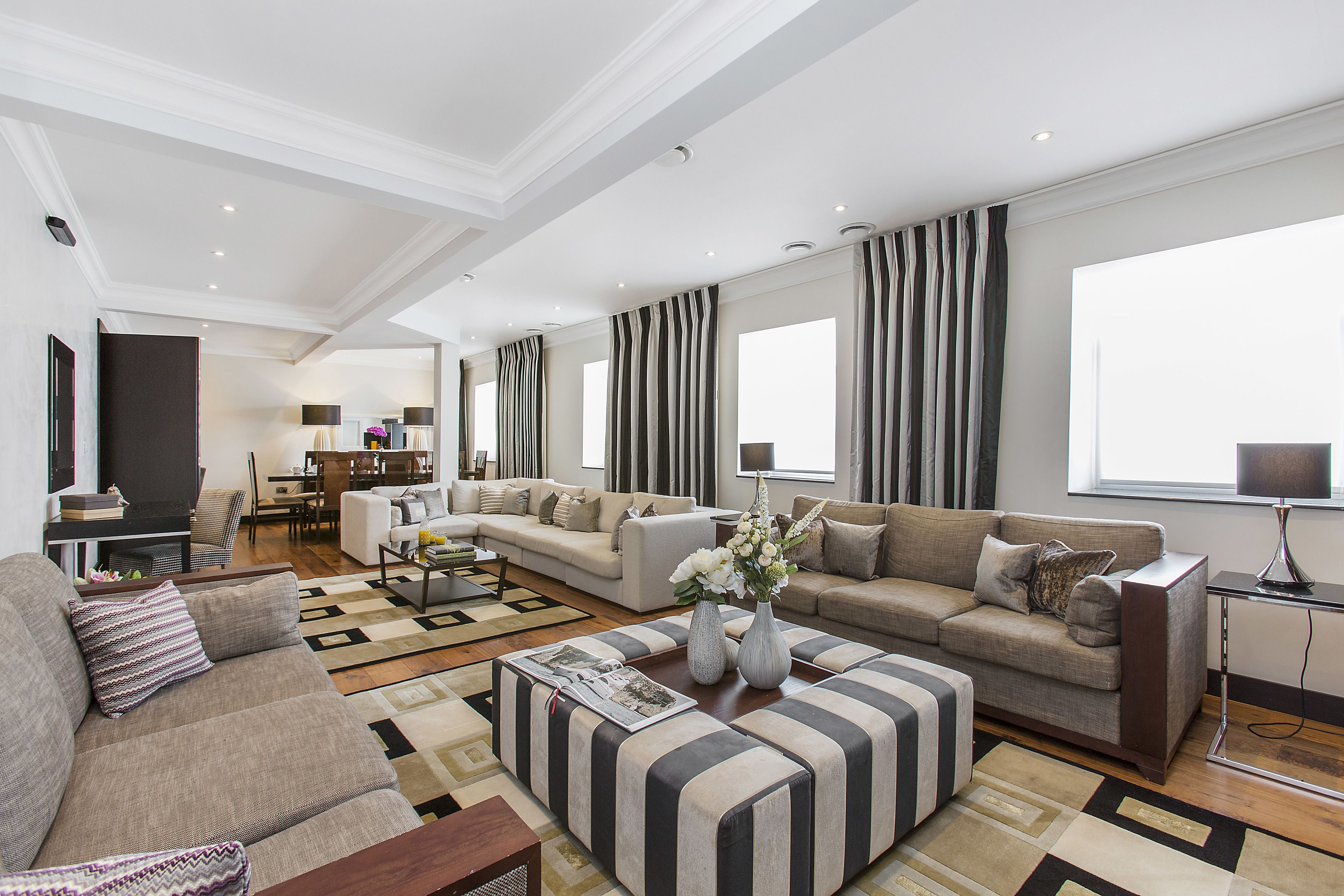 A spacious living room with a sectional sofa, a coffee table, and a TV.