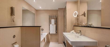 Un baño moderno con un espejo grande, un lavabo, un inodoro y un perchero para toallas.