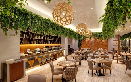 A modern cafe with a counter, seating area, and decorative hanging lights.