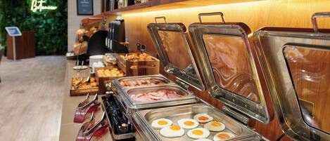 A buffet with various food options including eggs, ham, and other dishes.