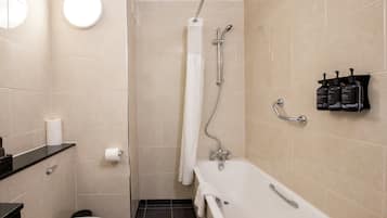 A bathroom with a toilet, sink, bathtub, shower, and towel rack.
