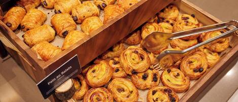 Une vitrine remplie de pâtisseries dans le rayon boulangerie d’un hôtel.