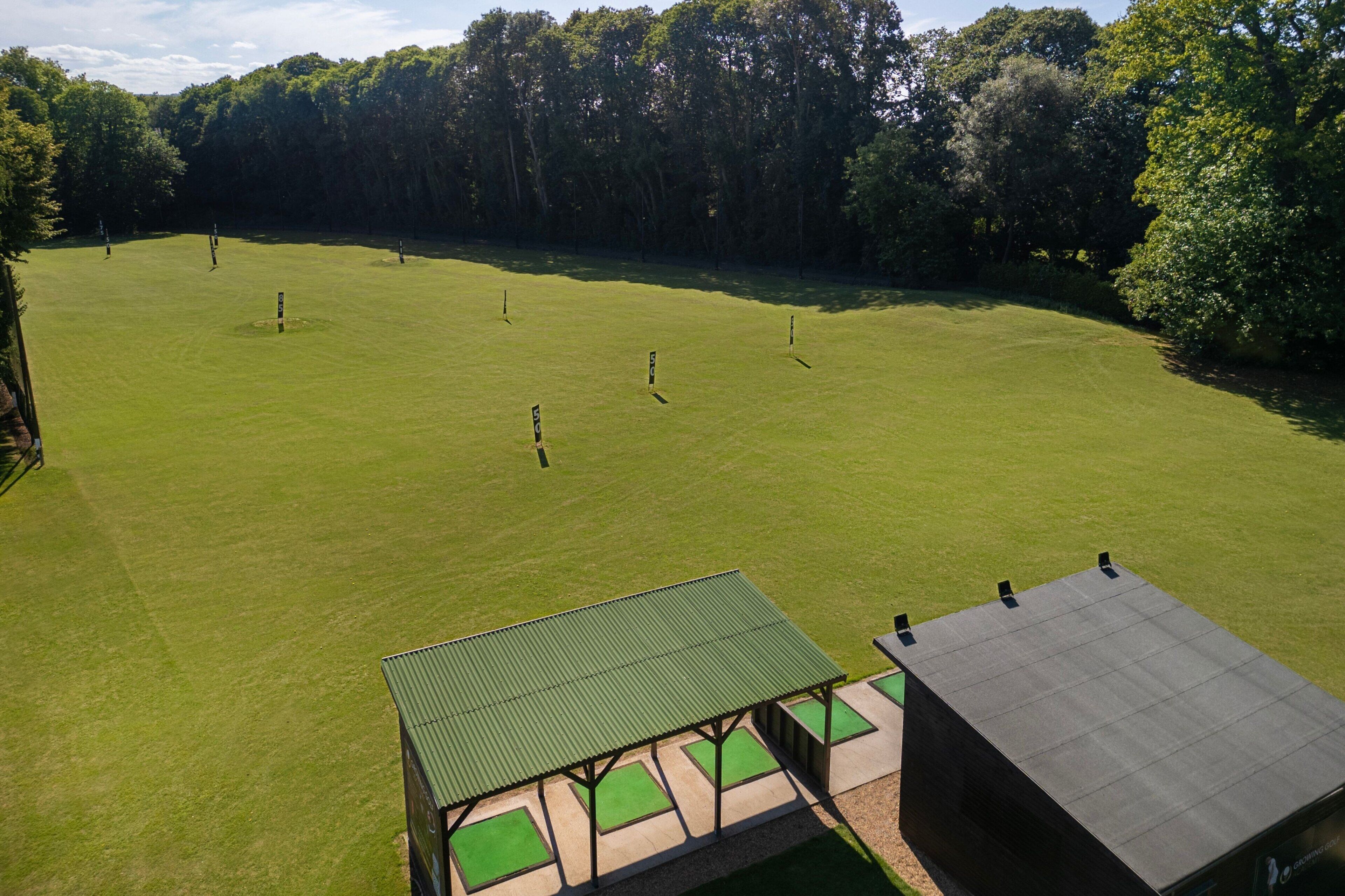 An aerial view of a golf course with a clubhouse and a small pavilion.