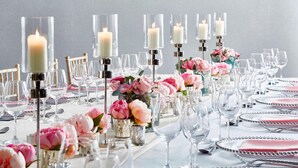 A table set for a formal event with clear glass candle holders, pink flowers, and silverware. - Delta Hotels by Marriott Tudor Park Country Club (Maidstone)