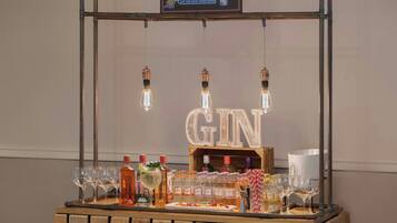 A gin bar setup with bottles, glasses, and a wooden counter.