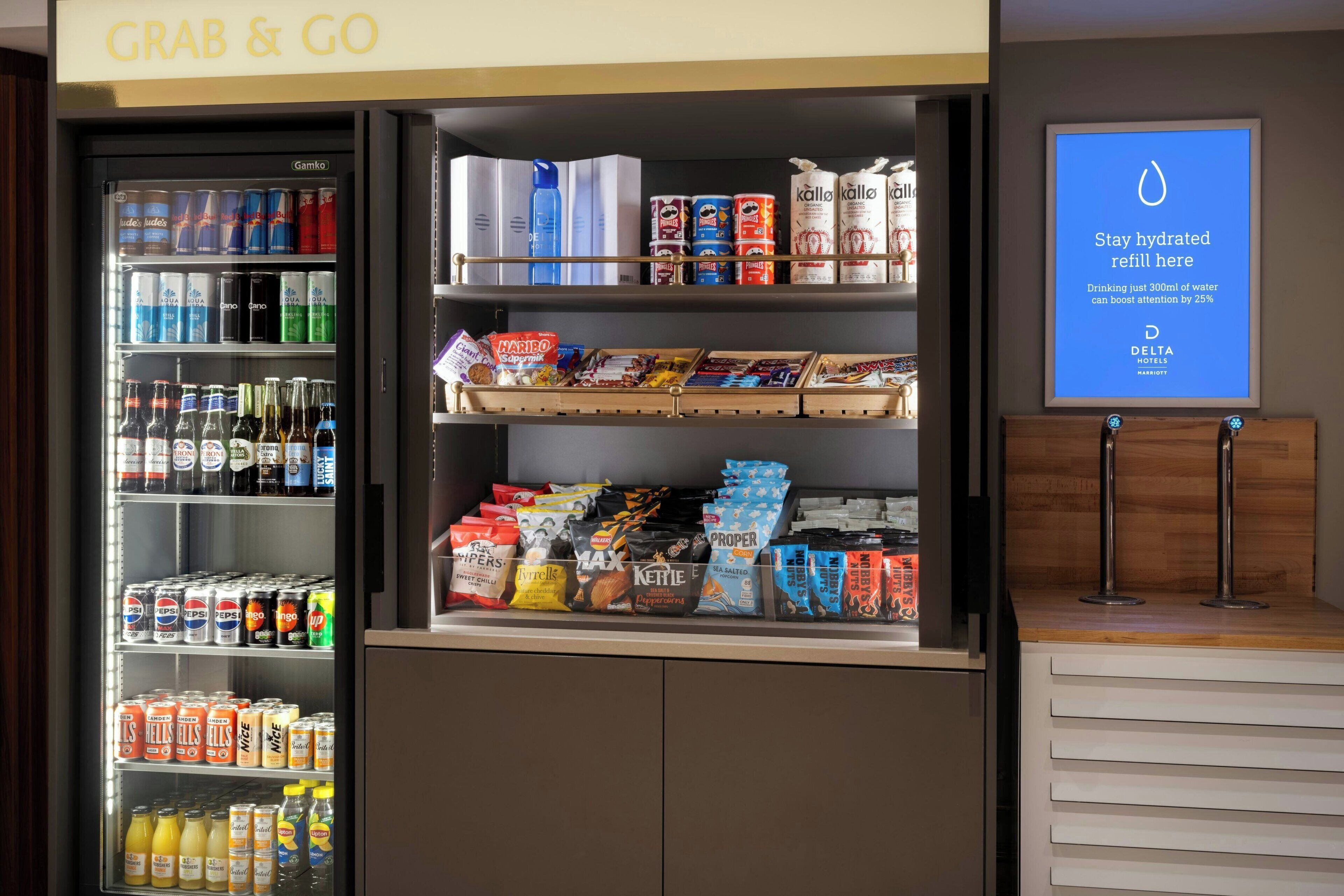 A vending machine with a variety of drinks and snacks, including bottled water, sodas, and energy drinks.