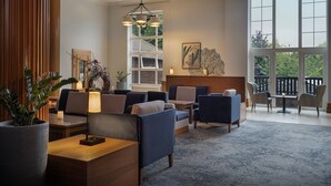 A spacious living area with comfortable seating, a large window, and a view of the outdoors. - Delta Hotels by Marriott Tudor Park Country Club (Maidstone)