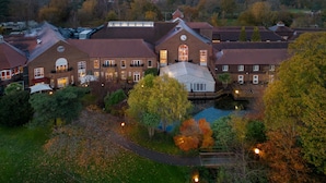 A large, historic building with multiple wings, a central courtyard, and a small pond. - Delta Hotels by Marriott Tudor Park Country Club (Maidstone)