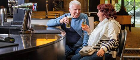 Un homme et une femme sont assis au bar du hall d’un hôtel.