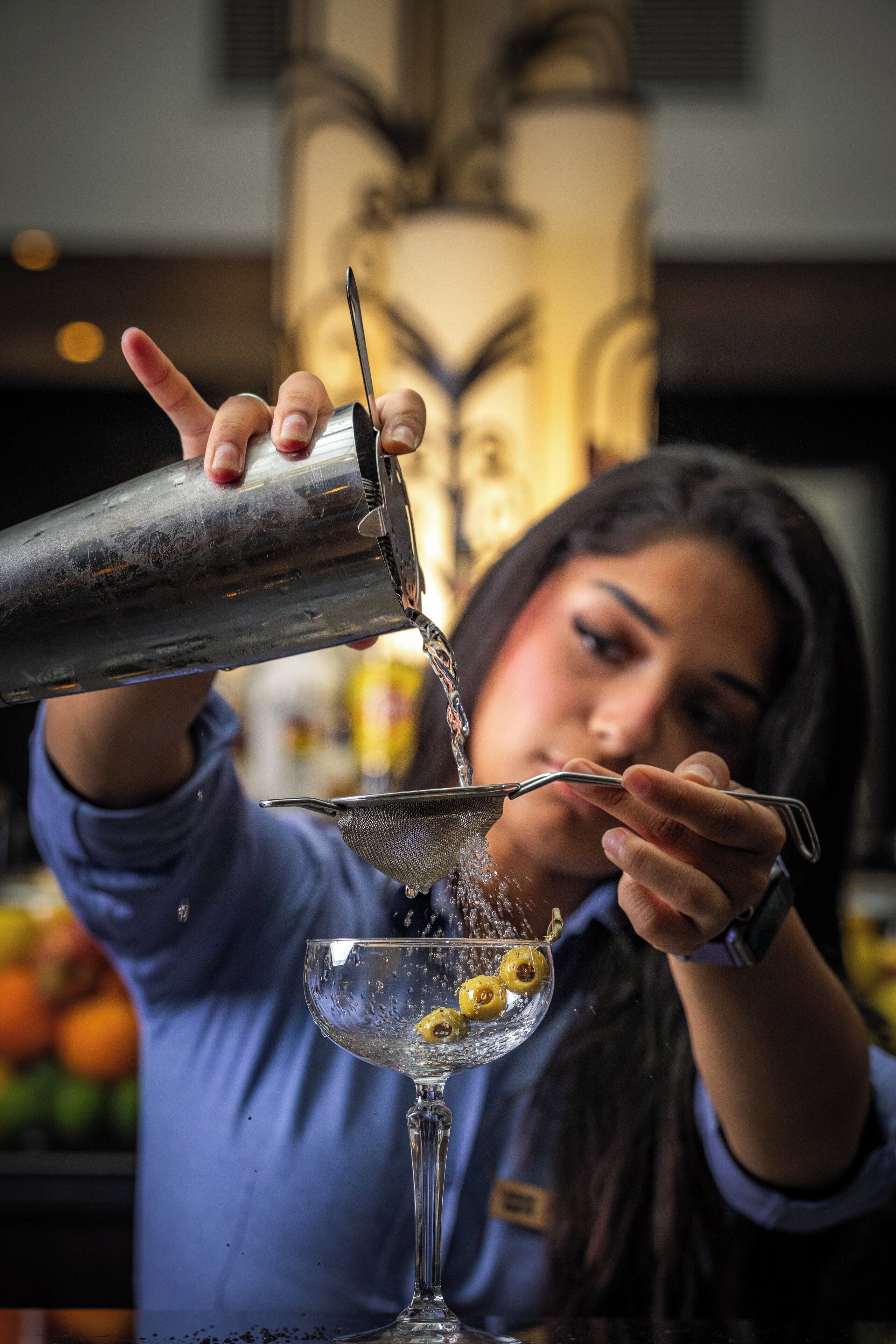 Una persona sirviendo una bebida en un vaso.