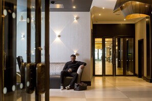 Guests can relax in the stylish lobby, featuring a geometric wall design and ambient lighting.