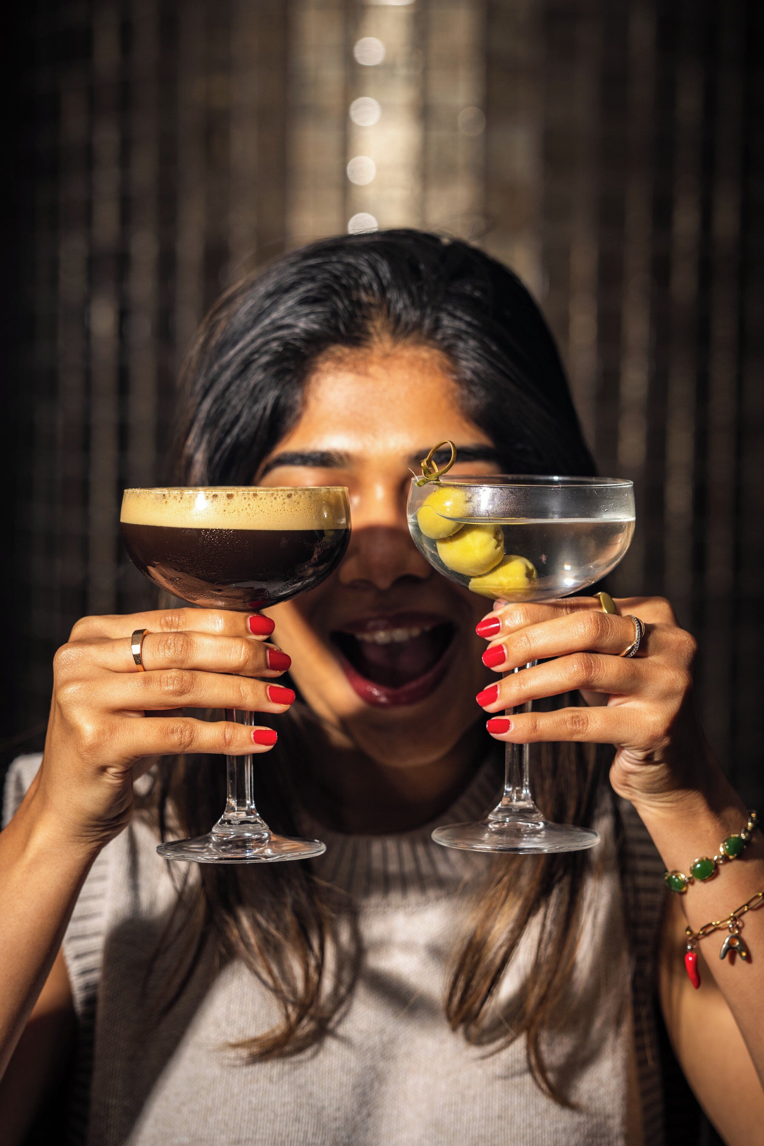 Una persona sosteniendo dos vasos de bebidas.